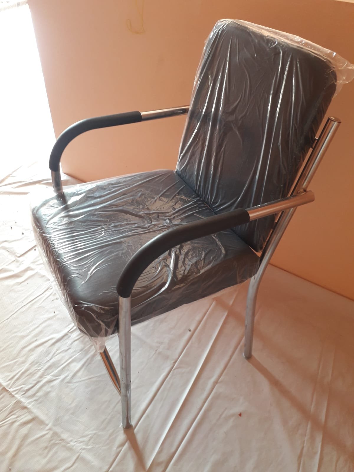 Black cushioned office visitor chair with metal frame and armrests - Image 3