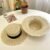 Elegant natural straw wide brim hat for women with decorative black band for beach travel and summer outdoor fashion